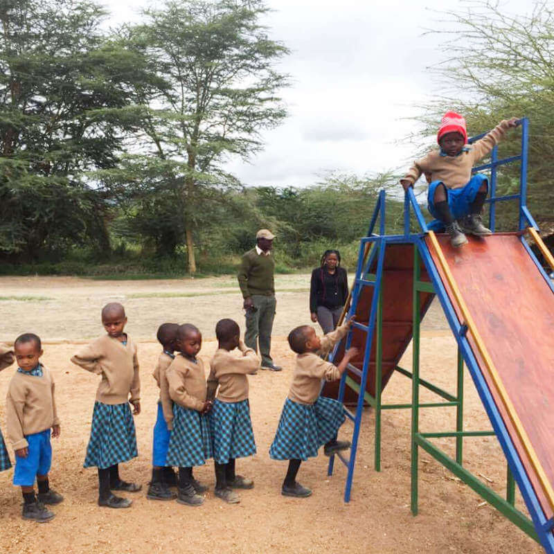 Bandari Project students waiting in line at Playground slide