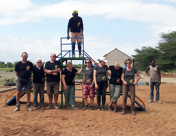 The Bandari Project Volunteers in Tanzania standing together at new playground equipment