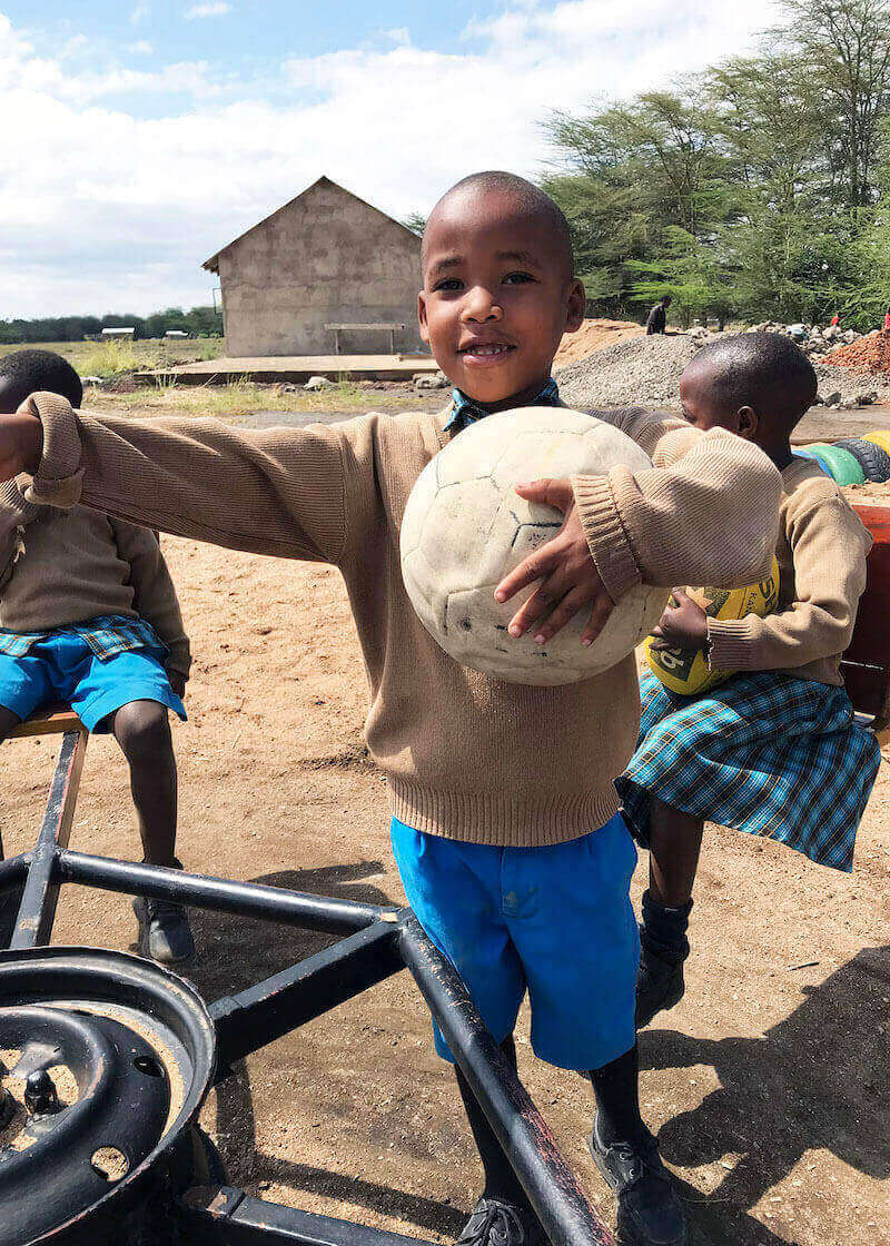 Bandari Project Student holding soccer ball in Playground